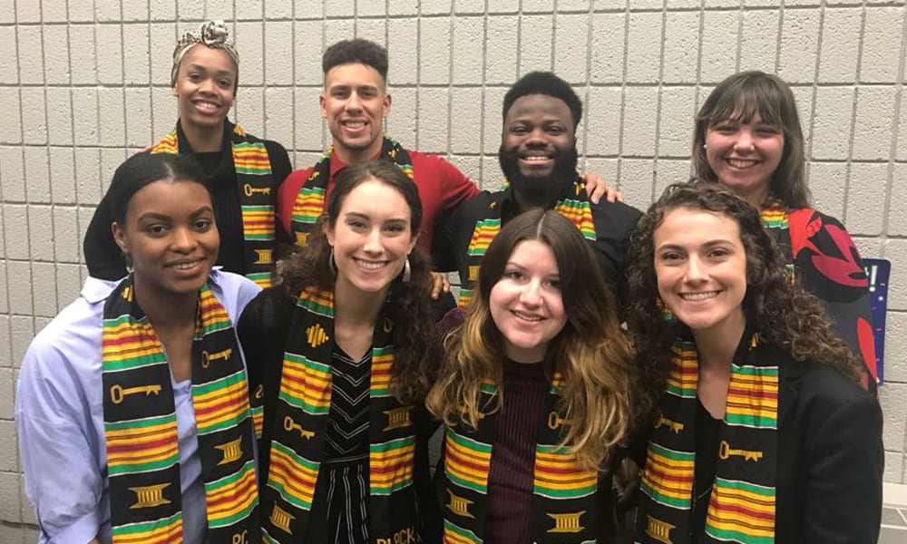 group of 8 students wearing Black Studies graduation scarves